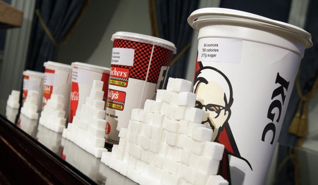 File photo of various size soft drink cups next to stacks of sugar cubes. Photo: AP