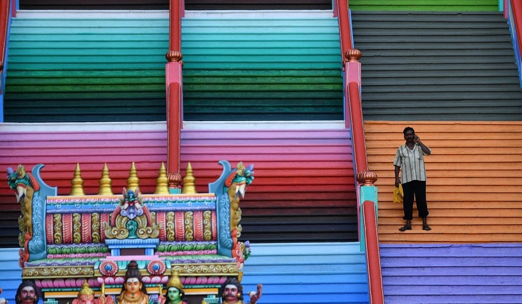 A man speaks on his mobile phone on the 272-step staircase leading to Malaysia’s Batu Caves Hindu temple in Kuala Lumpur on August 30, 2018. Photo: AFP