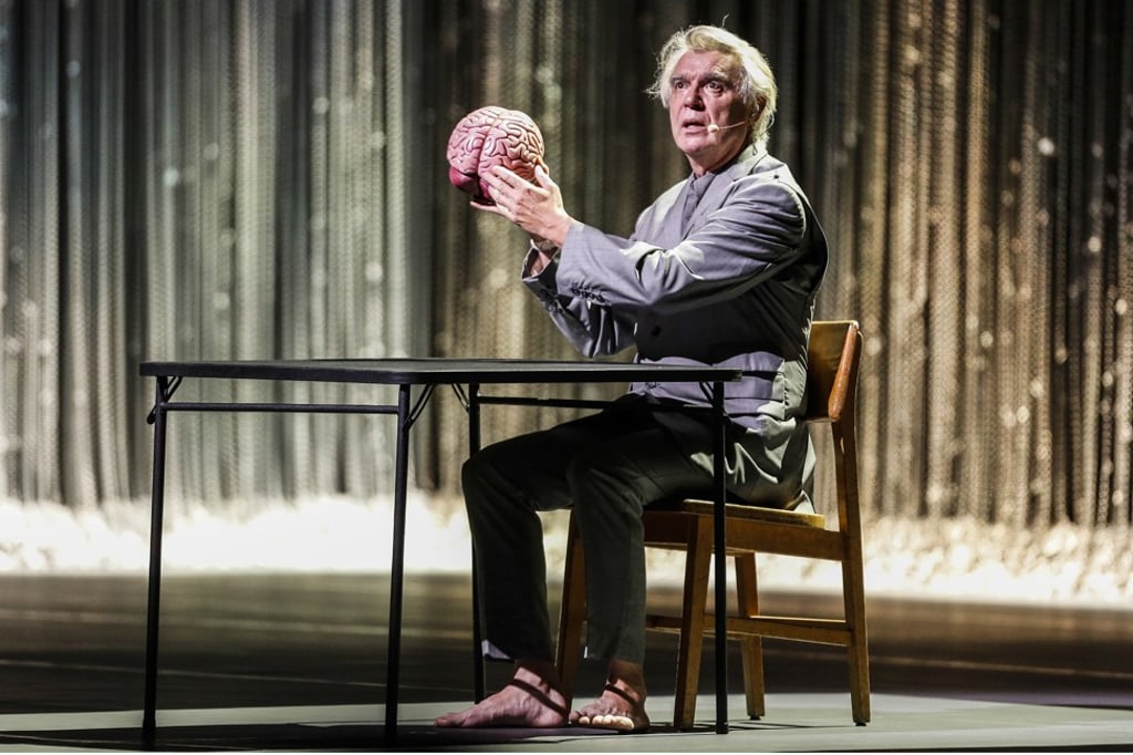 Byrne begins his set seated centre-stage at a card table, with a human brain on it. Photo: TNS Byrne begins his set seated centre-stage at a card table, with a human brain on it. Photo: TNS