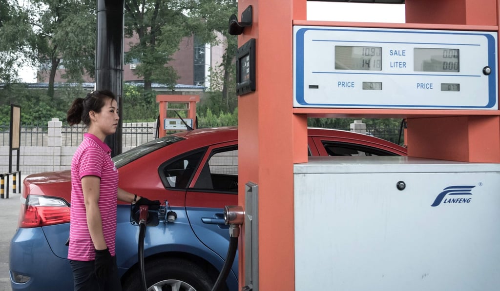 An attendant fills up a taxi with petrol in Pyongyang. Photo: AFP