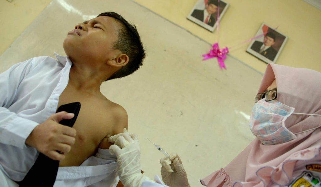 A nurse vaccinates a boy at his school in Banda Aceh, where the take-up rate for the immunisation programme is just 7 per cent. Photo: AFP