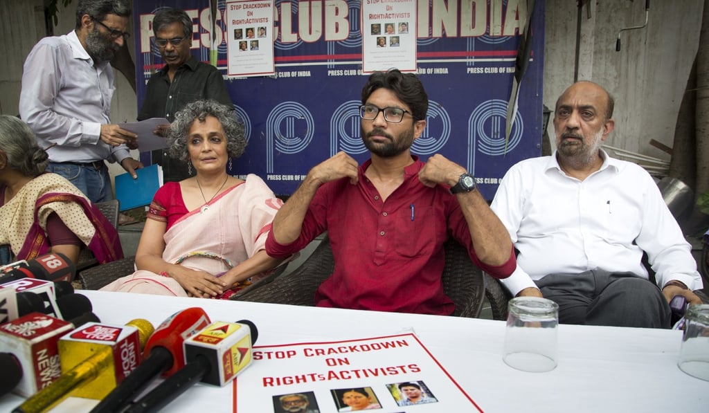Indian legislator and Dalit leader Jignesh Mevani, centre, writer activist Arundhati Roy, left, and activist Sanjay Parikh sit for a press conference opposing the arrests this week of five prominent rights activists, in New Delhi, India. Photo: AP