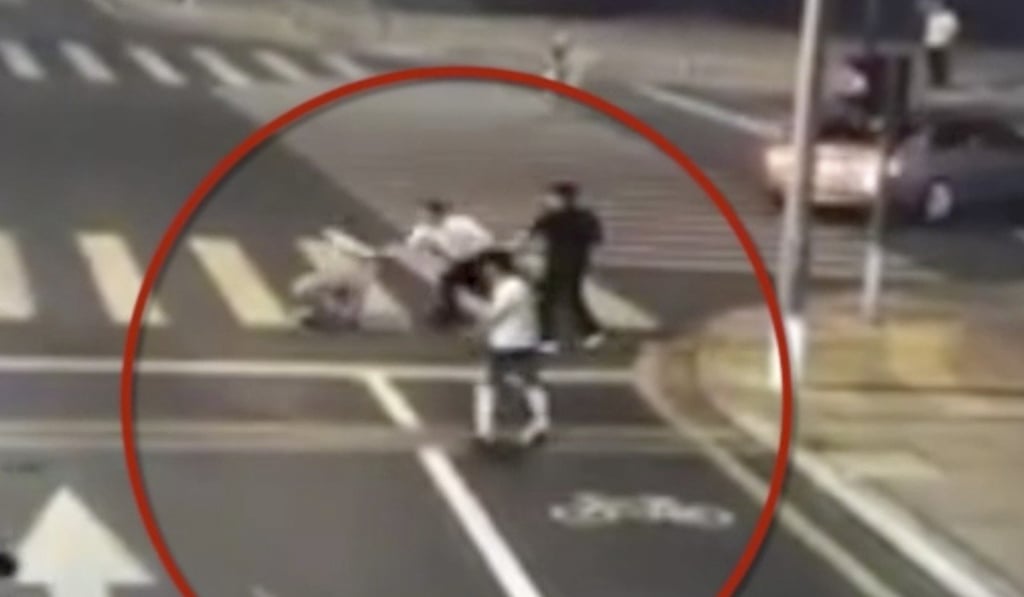 The pair ran into the road and the cyclist wrestled the driver to the ground. Photo: Baidu