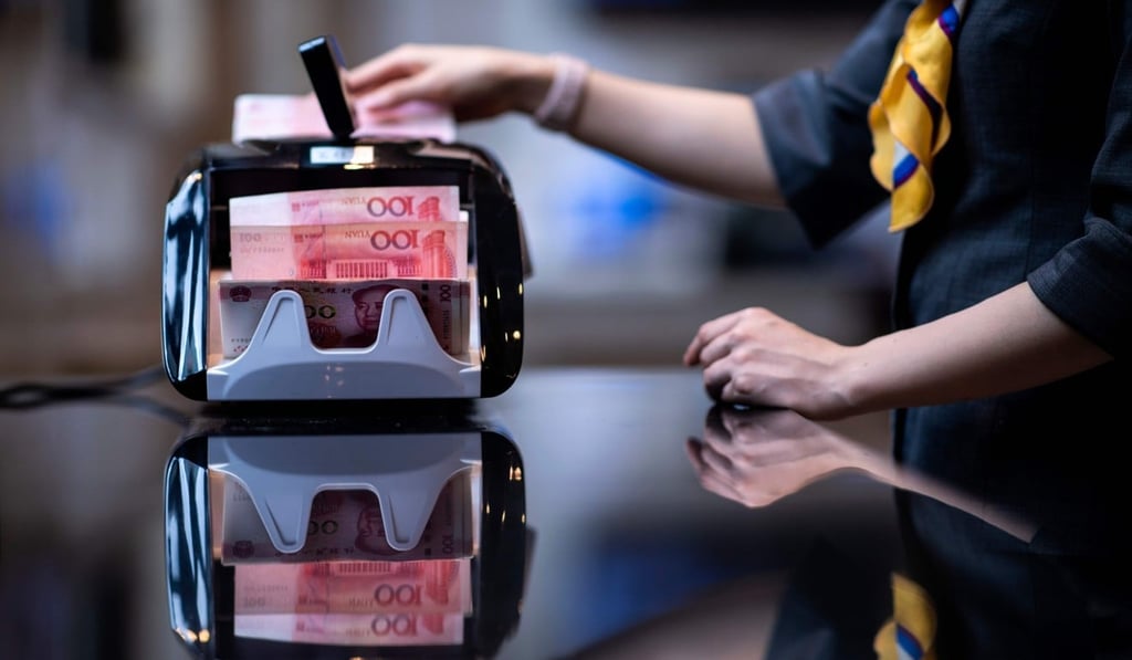 A bank employee uses a money-counting machine to count out 100 yuan notes in Shanghai on August 8. Photo: AFP