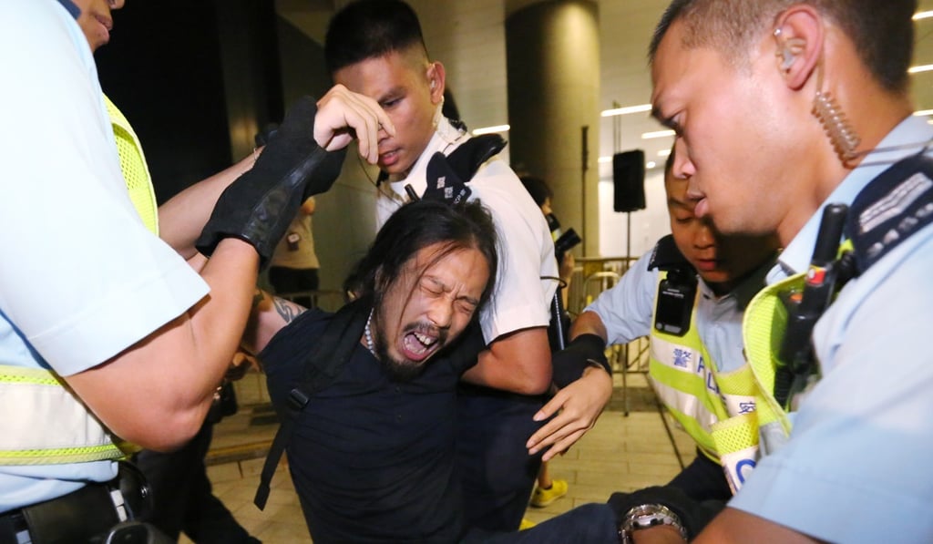 Police remove one of the activists from the Legislative Council Building during the 2014 protest. Photo: Felix Wong