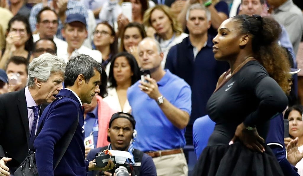Serena Williams looks on after her defeat as umpire Carlos Ramos leaves the court. Photo: AFP