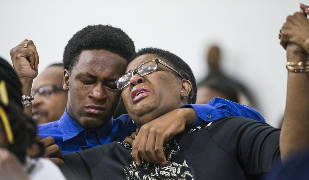 Allison Jean raises her hands in the air as she leans on her son, Grant, 15, during a prayer service for her son and Grant's brother Botham Jean at the Dallas West Church of Christ on Sunday. Photo: AP Allison Jean raises her hands in the air as she leans on her son, Grant, 15, during a prayer service for her son and Grant's brother Botham Jean at the Dallas West Church of Christ on Sunday. Photo: AP
