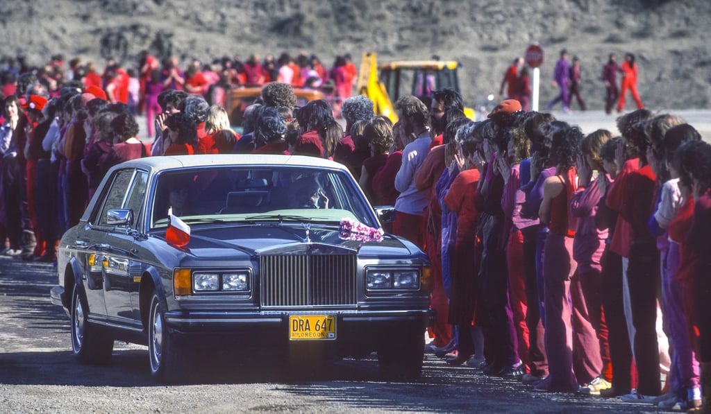 Religious leader Bhagwan Shree Rajneesh driving by and greeting his followers from one of his Rolls Royces in 1984. Photo: Alamy
