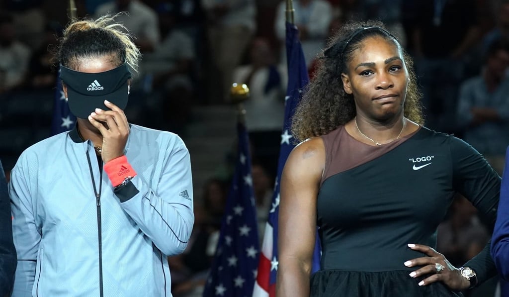 Naomi Osaka (left) pulls her visor down over her tearful face, as fans boo during the awards ceremony after she beat Serena Williams in the US Open final. Photo: AFP