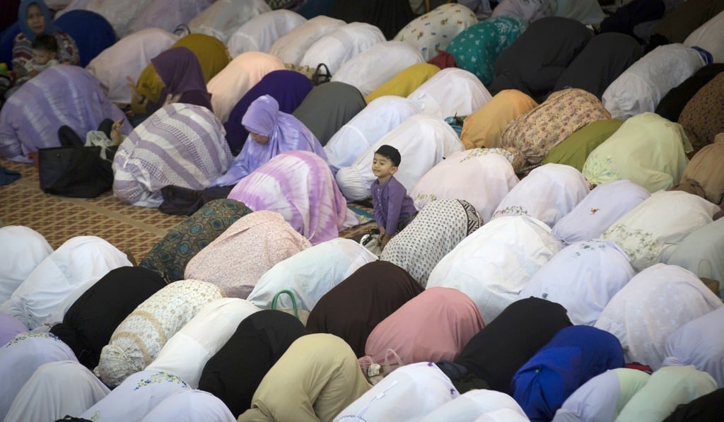 A Muslim boy waits while his parents offer prayers on the first day of Eid al-Fitr, which marks the end of the holy fasting month of Ramadan, in Kuala Lumpur, Malaysia, on June 15. Malaysia’s New Economic Policy aimed to narrow the wealth gap, by uplifting Malays and other indigenous communities. Photo: AP