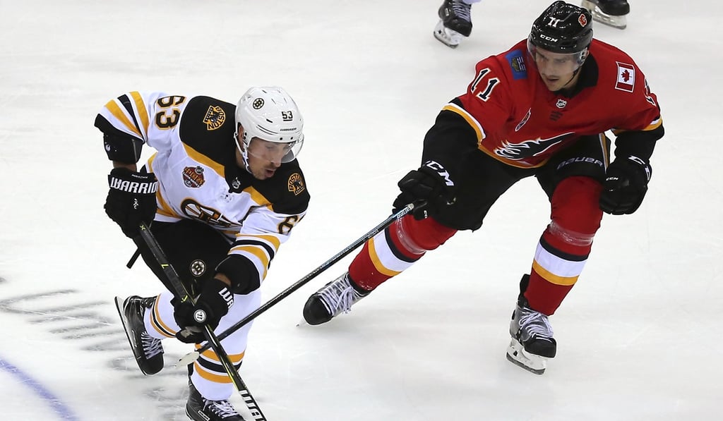 Marchand skates with the puck past Mikael Backlund of the Calgary Flames during their game in the 2018 NHL China Games in Shenzhen. Photo: AP