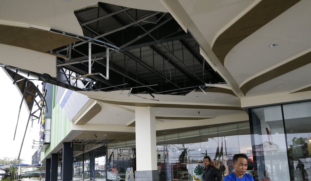 Residents stand beside a damaged portion of a mall in Tuguegarao city in Cagayan province, northeastern Philippines. Photo: AP
