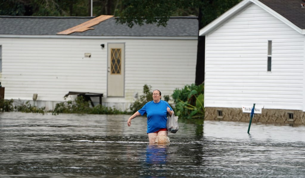 A woman walks through a flooded street after the storm struck Piny Green, North Carolina. Photo: Reuters