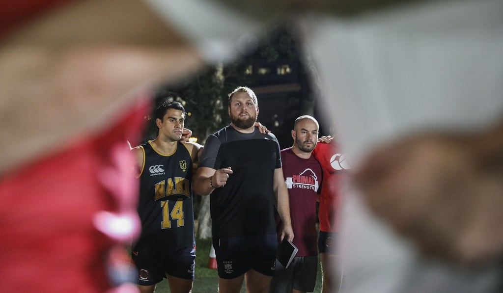 Coach Brett Wilkinson (centre) leads a training session at Aberdeen Sports Ground. Photo: K.Y. Cheng