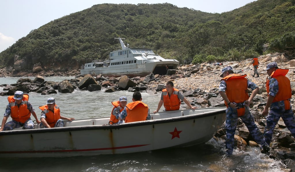 PLA members on the coast where a stranded military vessel has run aground. Photo: Sam Tsang