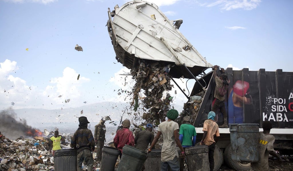 Scavengers wait for a truck to finish dumping its load at the Truitier landfill in the Cite Soleil slum of Port-au-Prince, Haiti. Photo: AP Scavengers wait for a truck to finish dumping its load at the Truitier landfill in the Cite Soleil slum of Port-au-Prince, Haiti. Photo: AP