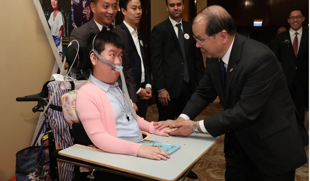 Josy Chow Pui-shan (left), who has spinal muscular atrophy, with Chief Secretary Matthew Cheung Kin-chung. Photo: Felix Wong Josy Chow Pui-shan (left), who has spinal muscular atrophy, with Chief Secretary Matthew Cheung Kin-chung. Photo: Felix Wong