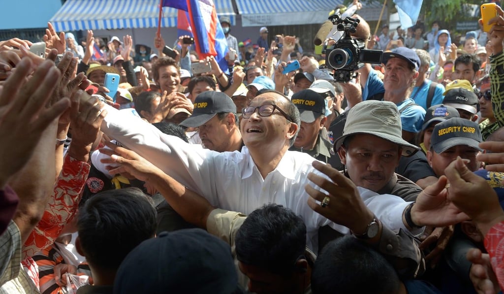 Photo taken on October 23, 2013 shows Australian James Ricketson filming former opposition leader Sam Rainsy greeting supporters during a demonstration in Phnom Penh. Photo: AFP