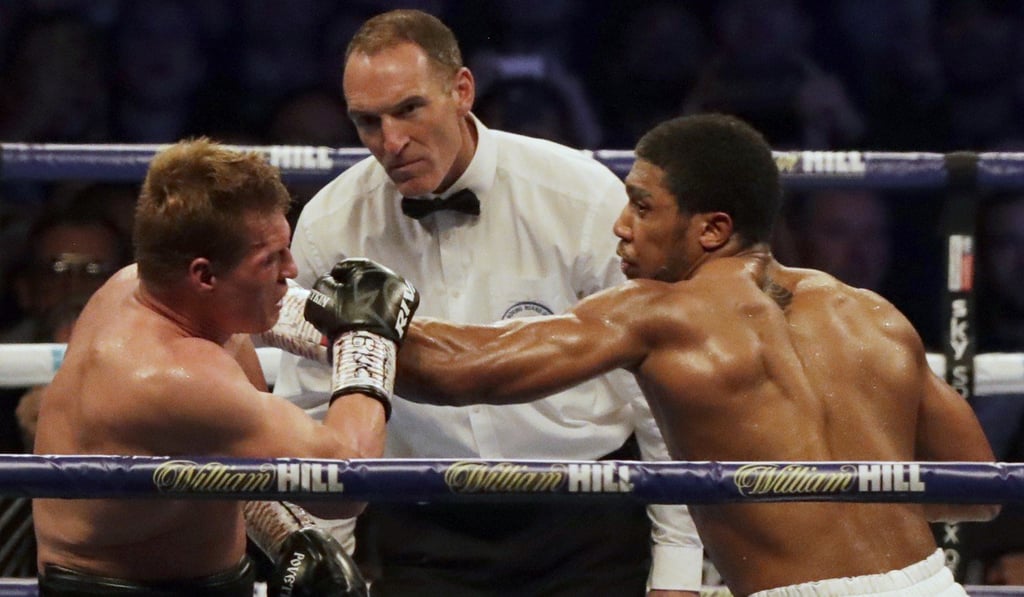 The referee watches closely seconds before stopping the fight, as Alexander Povetkin sustains pressure from Anthony Joshua. Photo: AP