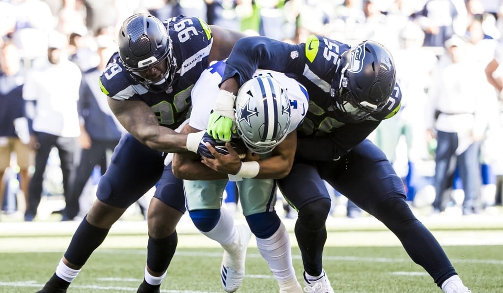 Dallas Cowboys quarterback Dak Prescott is sacked by Seattle Seahawks defensive tackle Quinton Jefferson (left) and defensive end Frank Clark. Photo: TNS Dallas Cowboys quarterback Dak Prescott is sacked by Seattle Seahawks defensive tackle Quinton Jefferson (left) and defensive end Frank Clark. Photo: TNS