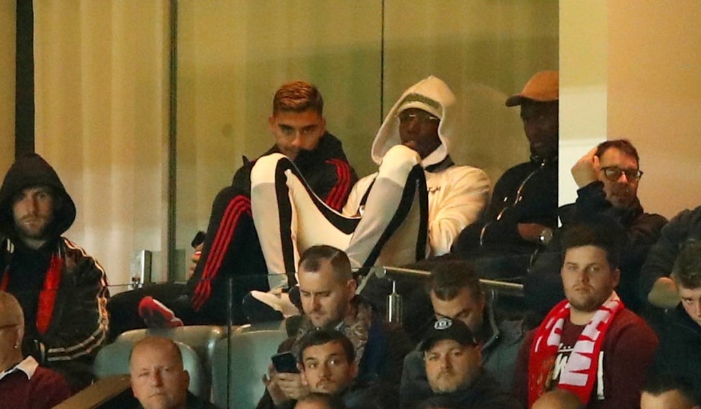 Pogba (centre) watches the match against Derby from the stands. Photo: Reuters
