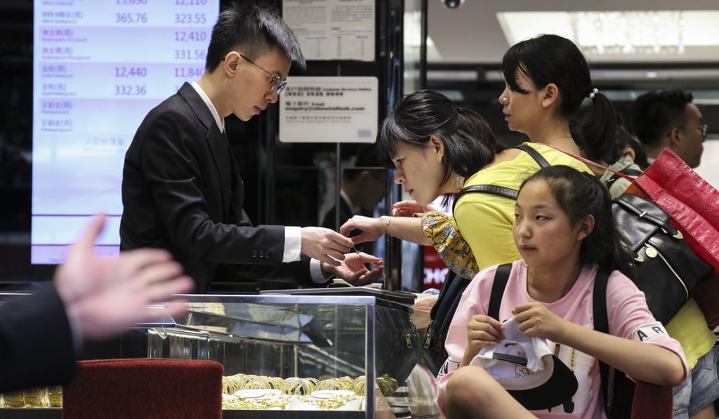 Customers inspect jewellery at a shop in Hong Kong on July 31. There is a much used private trading system for gold investors in the city. Photo: Felix Wong