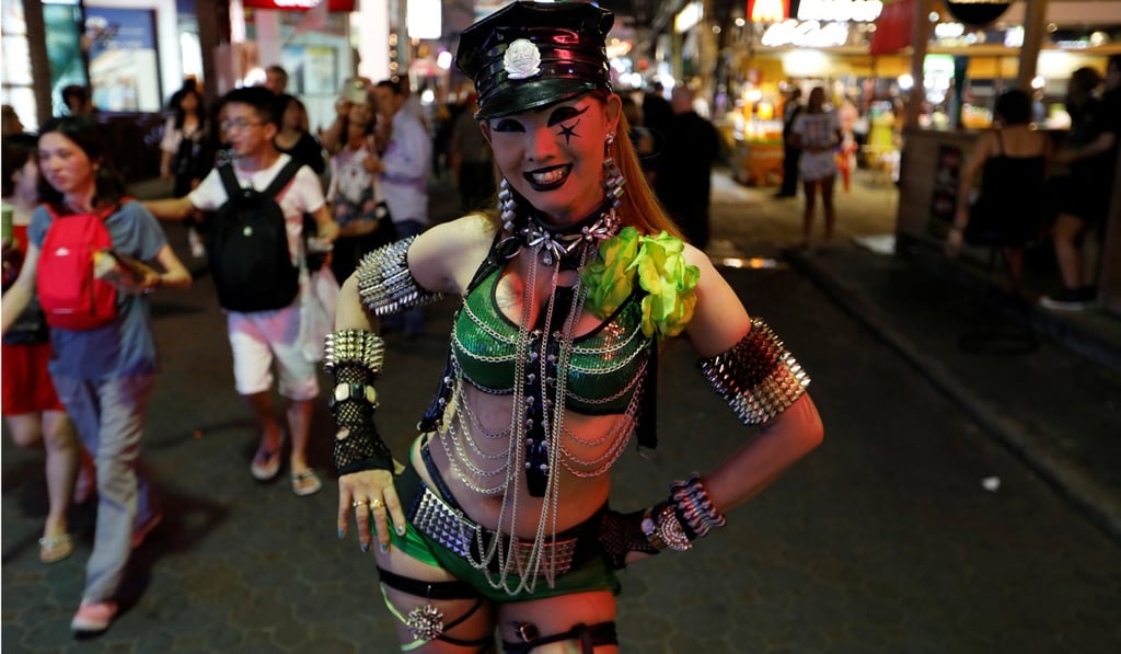 A woman promotes a go-go dance bar in Pattaya, Thailand. Photo: Reuters
