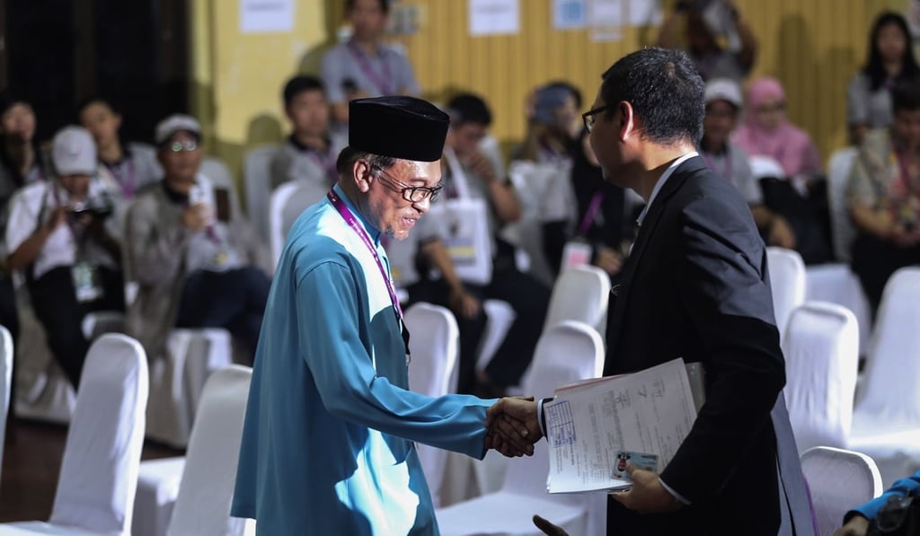 President of the People’s Justice Party and leader of the Pakatan Harapan coalition Anwar Ibrahim (left) shakes hands with independent candidate Saiful Bukhari Azlan after submitting his documents at the nomination centre for a by-election in Port Dickson on September 29, 2018. Photo: EPA