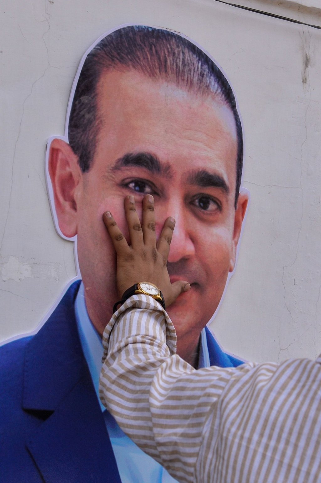 A protester keeps his hand on the face of a cut out of billionaire jeweller Nirav Modi during a protest in New Delhi. Photo: AFP A protester keeps his hand on the face of a cut out of billionaire jeweller Nirav Modi during a protest in New Delhi. Photo: AFP