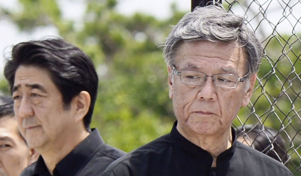 The late former Okinawa governor Takeshi Onaga (right) stands with Japanese Prime Minister Shinzo Abe during a memorial service for the war dead. Photo: AP The late former Okinawa governor Takeshi Onaga (right) stands with Japanese Prime Minister Shinzo Abe during a memorial service for the war dead. Photo: AP