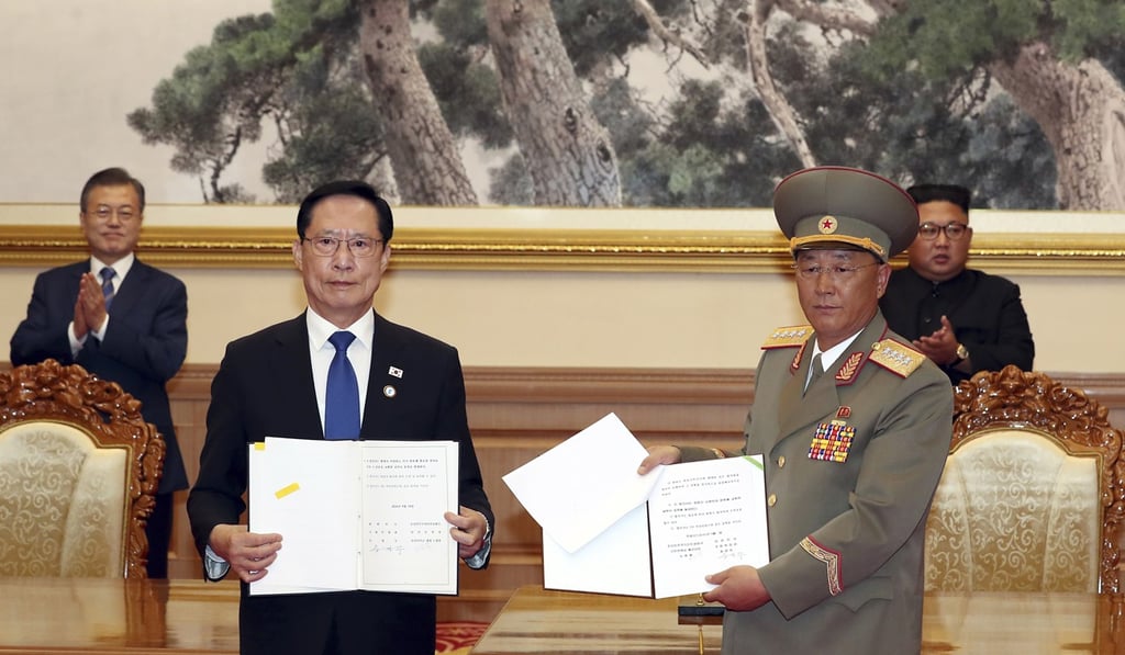 South Korea's Defence Minister Song Young-moo and North Korea's Minister of the People's Armed Forces No Kwang-chol hold the signed documents as South Korean President Moon Jae-in, rear left, and North Korean leader Kim Jong-un, rear right. Both parties agreed to remove mines from the DMZ. Photo: AP