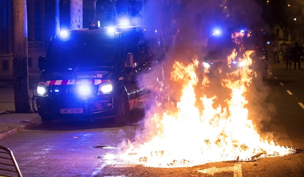 A Catalonian riot police van stands in front of a fire during a protest in Barcelona on Monday. Photo: EPA-EFE A Catalonian riot police van stands in front of a fire during a protest in Barcelona on Monday. Photo: EPA-EFE