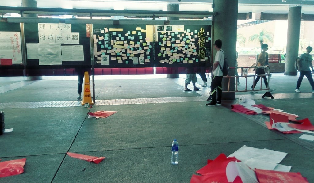Red paper covering messages in support of Hong Kong independence at Polytechnic University was torn down by a student on Tuesday afternoon. Photo: Handout