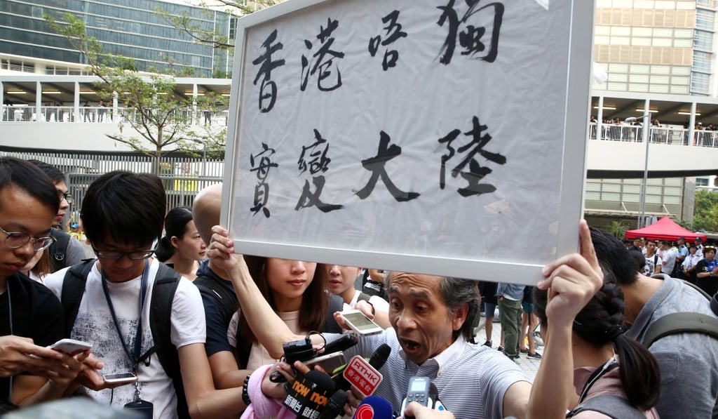 During a protest on National Day outside Tamar, a pro-independence activist holds up a placard with a rhyming message that translates as: “If Hong Kong doesn’t become independent, it will really become the mainland.” Photo: Edmond So