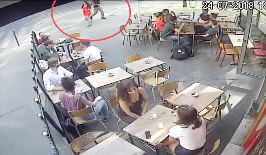 Marie Laguerre, in red at the top of screen, and her attacker cross paths outside a cafe in Paris on Tuesday July 24. Photo: YouTube