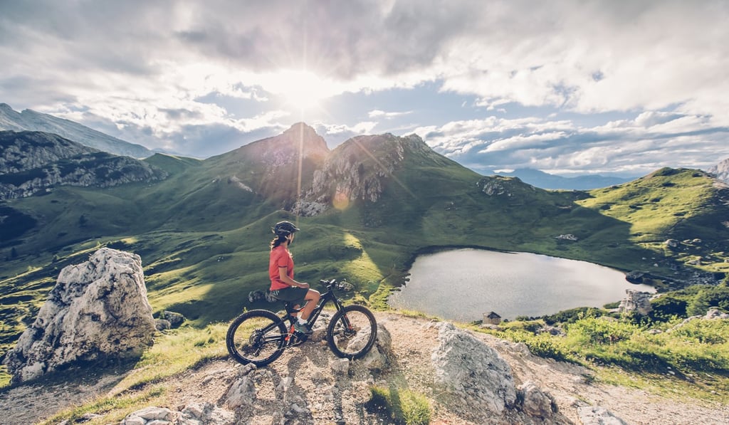 A rider sits on their e-bike and looks out over the Dolomites in Italy.
