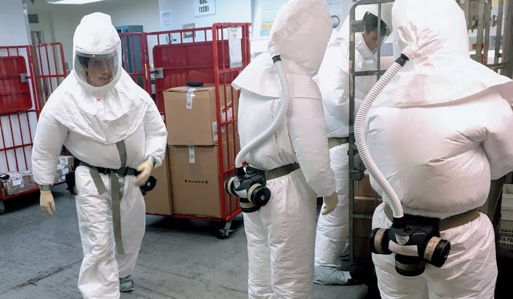 US Defence Department personnel, wearing protective suits, screen mail as it arrives at a facility near the Pentagon on Tuesday. Photo: AFP