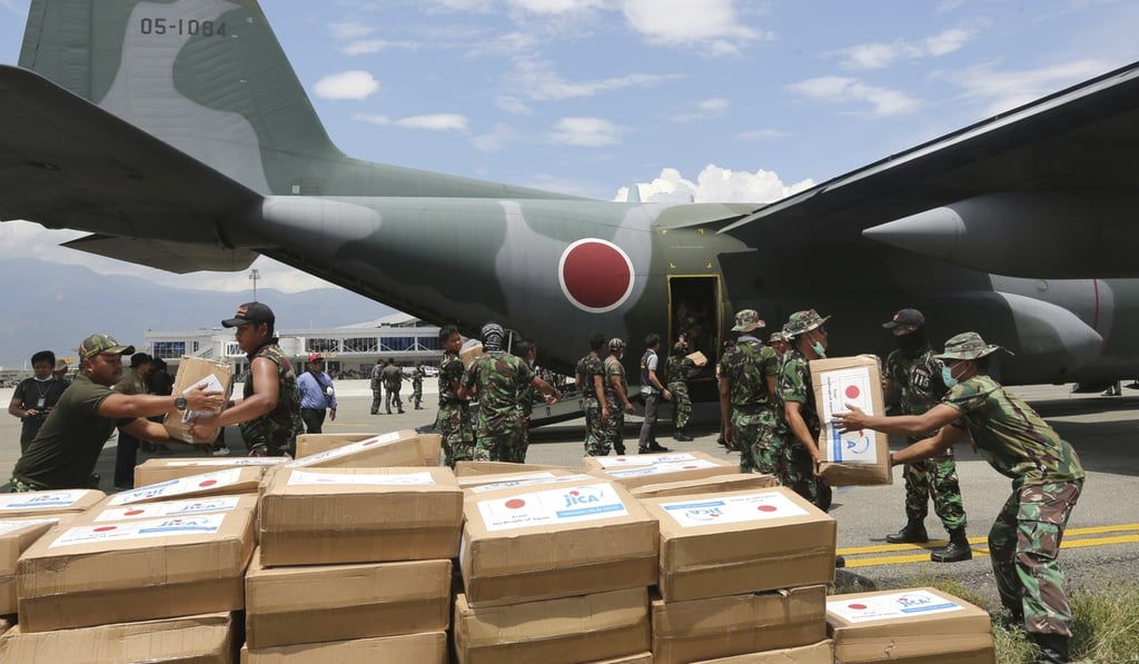 Indonesian and Japanese military personnel unload relief aid in Palu. Photo: AP Indonesian and Japanese military personnel unload relief aid in Palu. Photo: AP