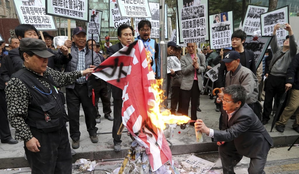 Protesters in Seoul burn a Japanese rising sun flag during a rally in 2013 to protest Japanese lawmakers who made a visit to Yasukuni Shrine in Tokyo. Photo: AP Protesters in Seoul burn a Japanese rising sun flag during a rally in 2013 to protest Japanese lawmakers who made a visit to Yasukuni Shrine in Tokyo. Photo: AP