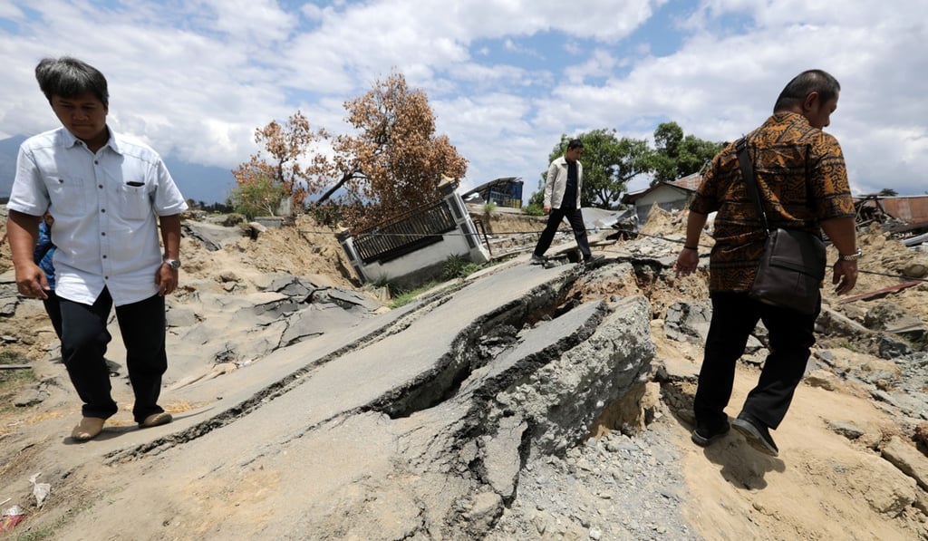 Residents navigate a broken street in Palu, Indonesia. Photo: EPA
