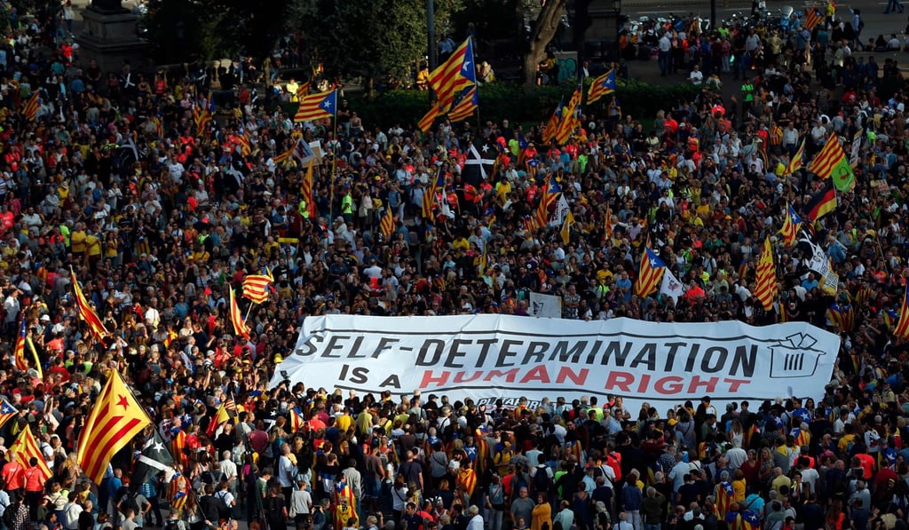 People unfold a banner demanding self-determination during a pro-Catalan demonstration in Barcelona. Photo: AFP