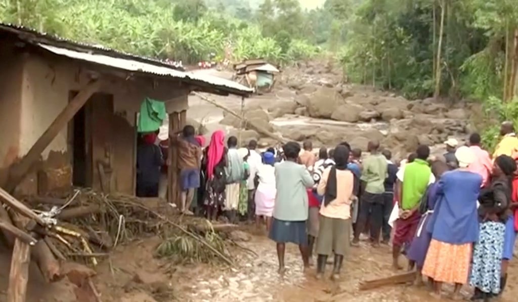 Residents watch flood waters pass through the destroyed homes. Photo: Reuters