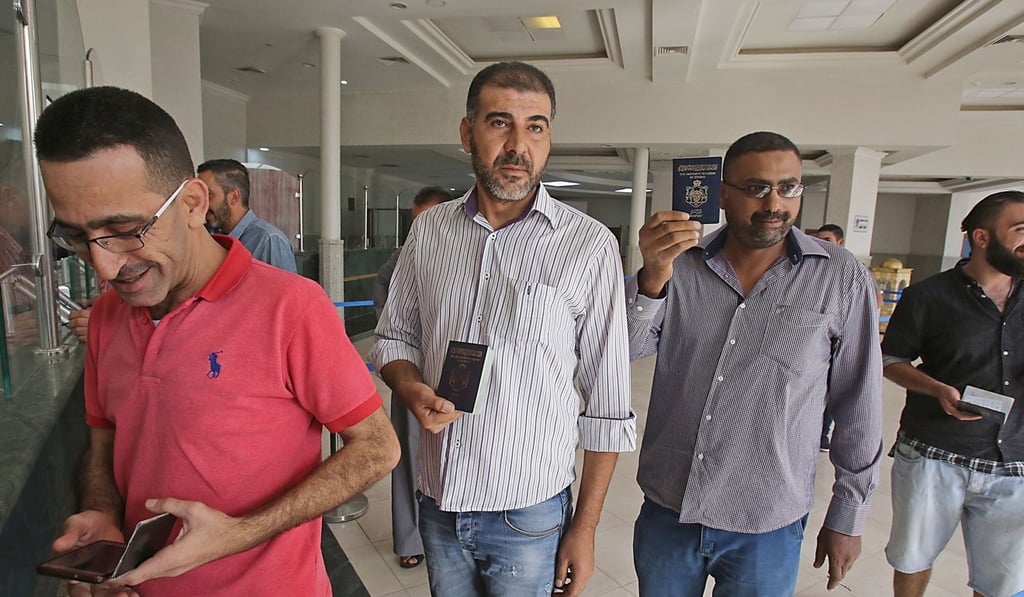 Jordanian men showing their passports at the border crossing between Jordan and Syria on the day of its reopening. Photo: AFP Jordanian men showing their passports at the border crossing between Jordan and Syria on the day of its reopening. Photo: AFP