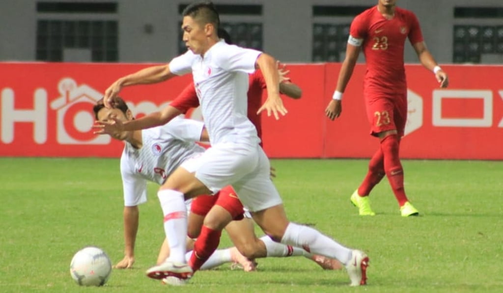 Hong Kong midfielder Huang Yang dribbles past an Indonesia player. Photo: HKFA