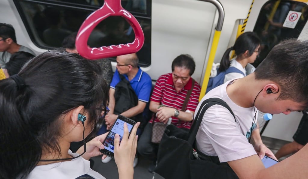 Young people using their smartphones on Hong Kong’s MTR train. Photo: Jonathan Wong