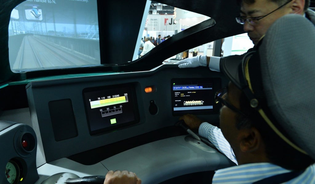 This 2015 file photo shows a Japanese engineer assisting an Indian man inside the 3D model of a Series E5 bullet train of the East Japan Railway Corporation during the 11th International Railway Equipment Exhibition in New Delhi. Photo: Agence France-Presse