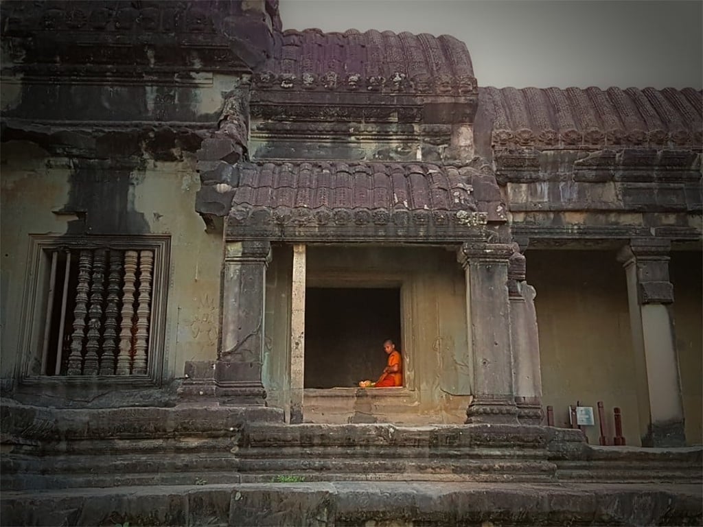 A novice monk meditates at Angkor Wat at dawn.