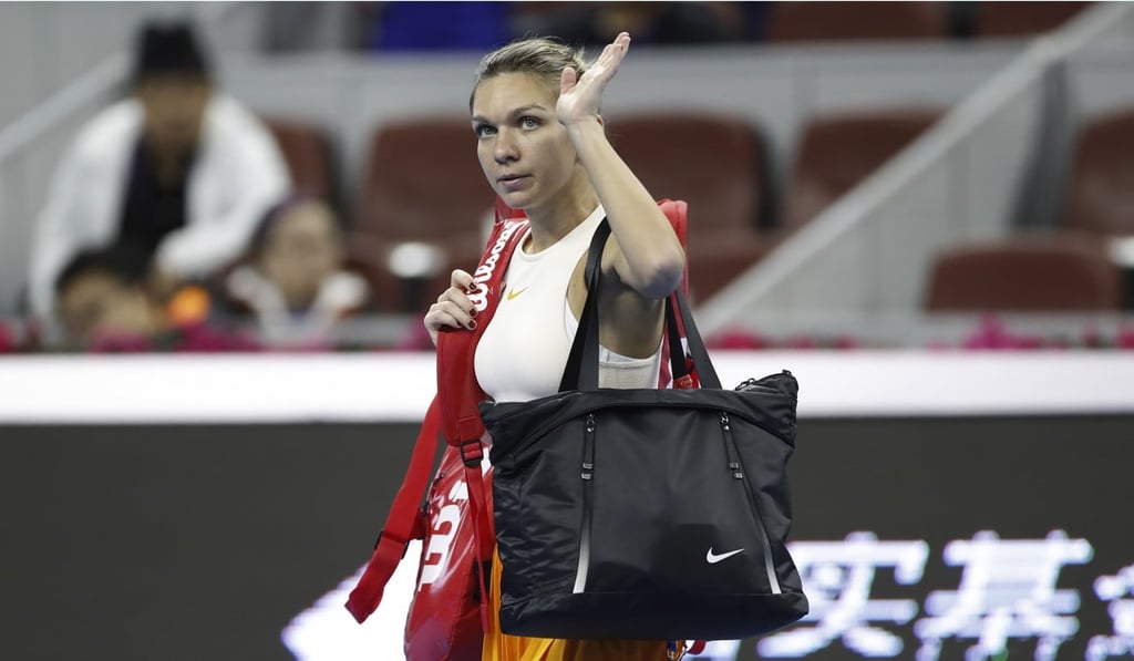 Simona Halep waves to spectators after retiring with her back injury during her first round match against Ons Jabeur at the China Open. Photo: AP