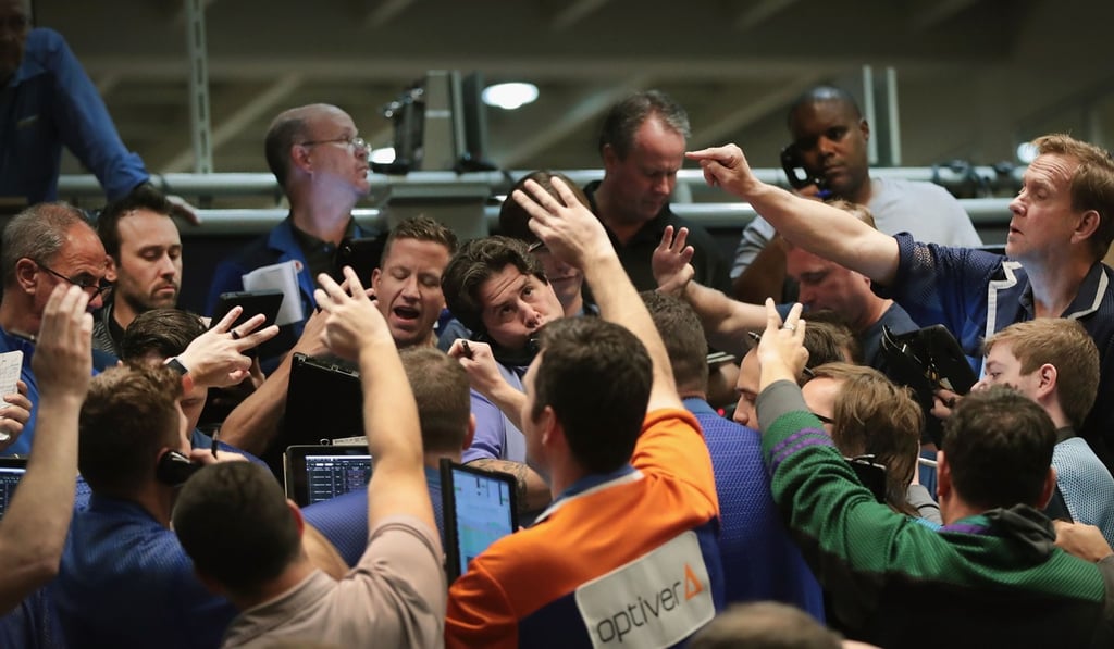 Traders signal offers in the S&P options pit at the Cboe Global Markets exchange shortly after the Federal Reserve announced it was raising interest rates on September 26, in Chicago. Photo: Agence France-Presse
