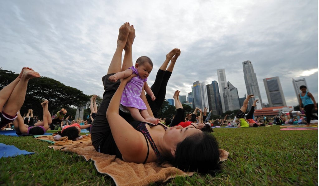 Parents and children practise yoga at Singapore’s Marina Bay. Photo: Xinhua